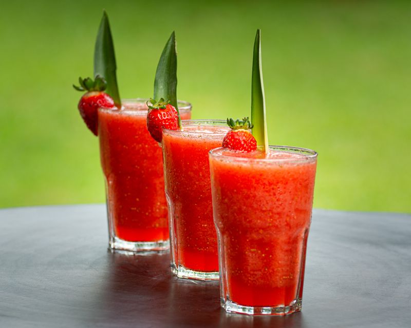 Trzy szklanki gazpacho truskawkowego udekorowane truskawką