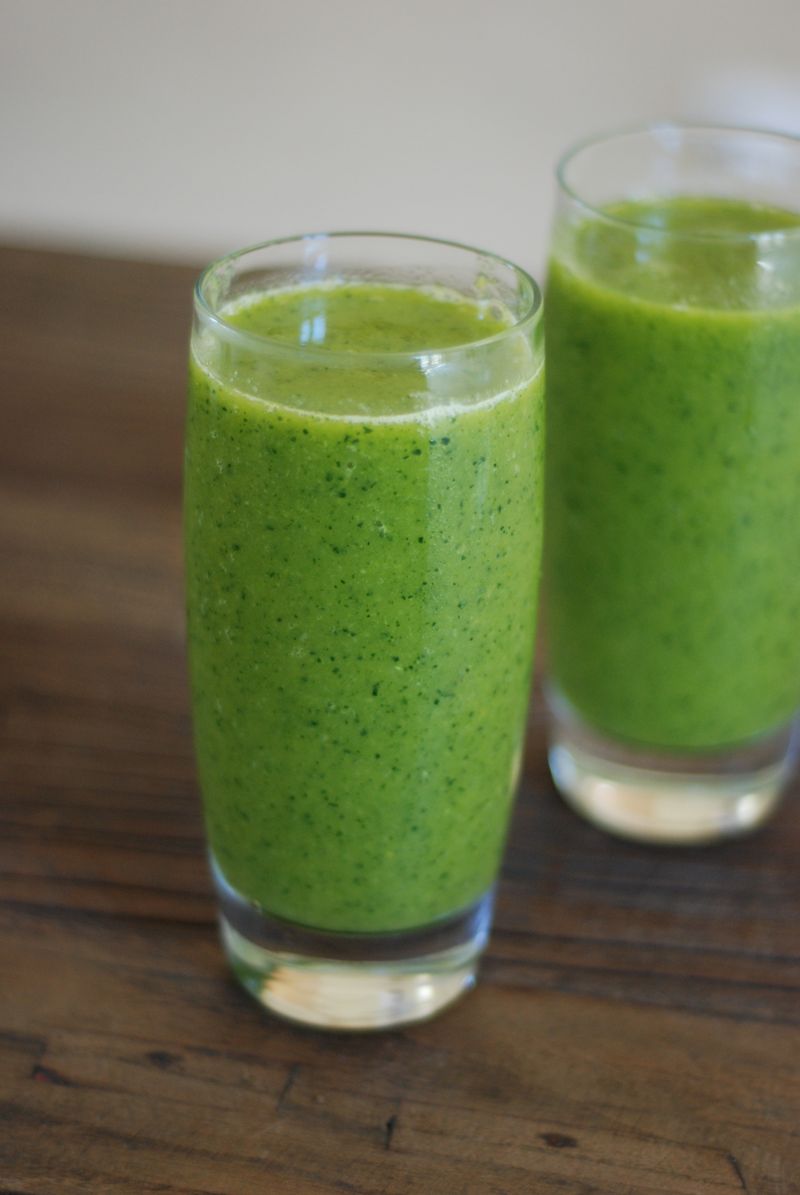 Dwie szklanki zielonego smoothie na drewnianym stole